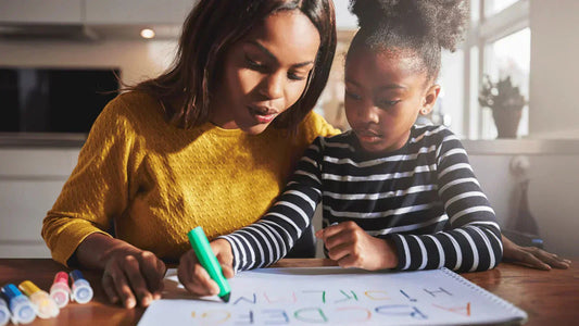 A mother and daugter calmly draw together on a kitchen table